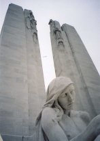 Looking up. The figure is not a protagonist from the French revolution, but a female mourner. There's also a male one on the other side of the entrance.